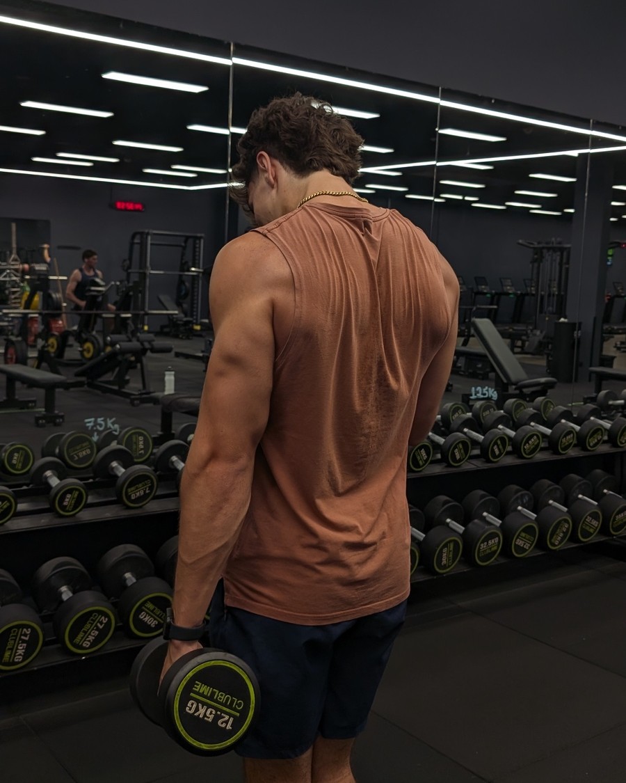 Toby Reeves training back and shoulders with a dumbbell at the gym